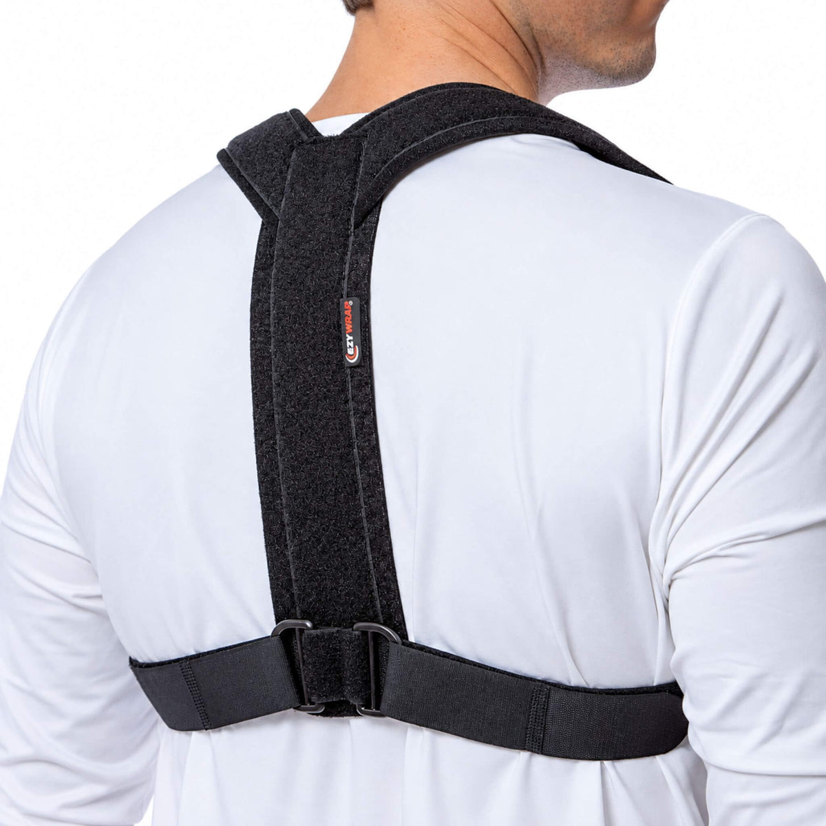 Man wearing an adjustable figure 8 clavicle brace, showing padded shoulder straps and D-ring closures from an angled back view.